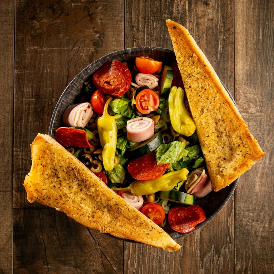 Gelsosomo's Pizzeria's antipasto salad with pepperoni, ham, tomatoes, olives, and garlic bread.